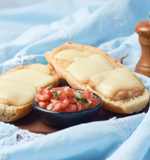 Molletes, typical Mexican food in wooden plate.